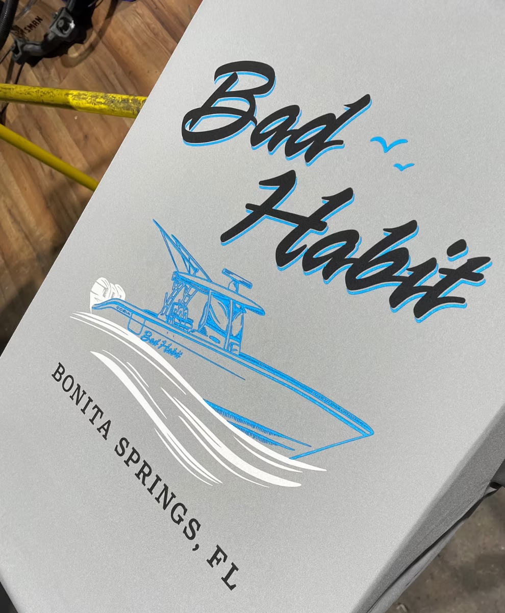 Bad Habit Bonita Springs, FL boat shirt screen printed in black, sky blue and white on a light gray performance shirt by Dad Bod Screen Printing